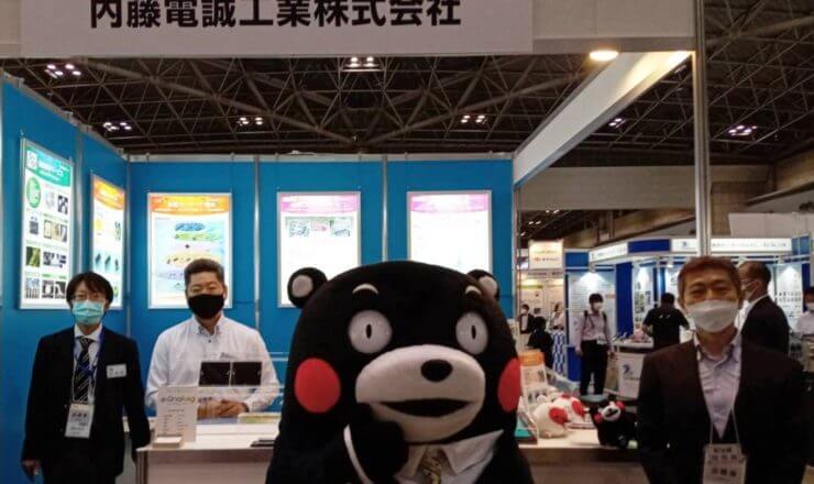 JPCAショー内藤電誠ブースにくまモンが来てくれました。スタッフ全員で記念撮影をしました。QFPやDIPパッケージを製造しているグループ会社の九州日誠電氣は熊本県上益城郡に工場を持っています。